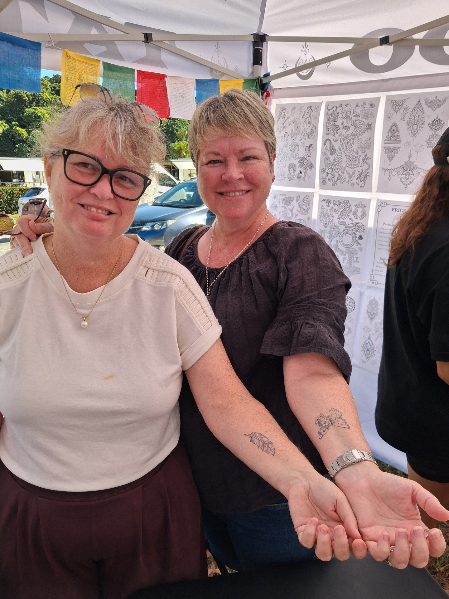 Happy guests showing their temporary tattoos at a Hokey Pokey Tatu studio event